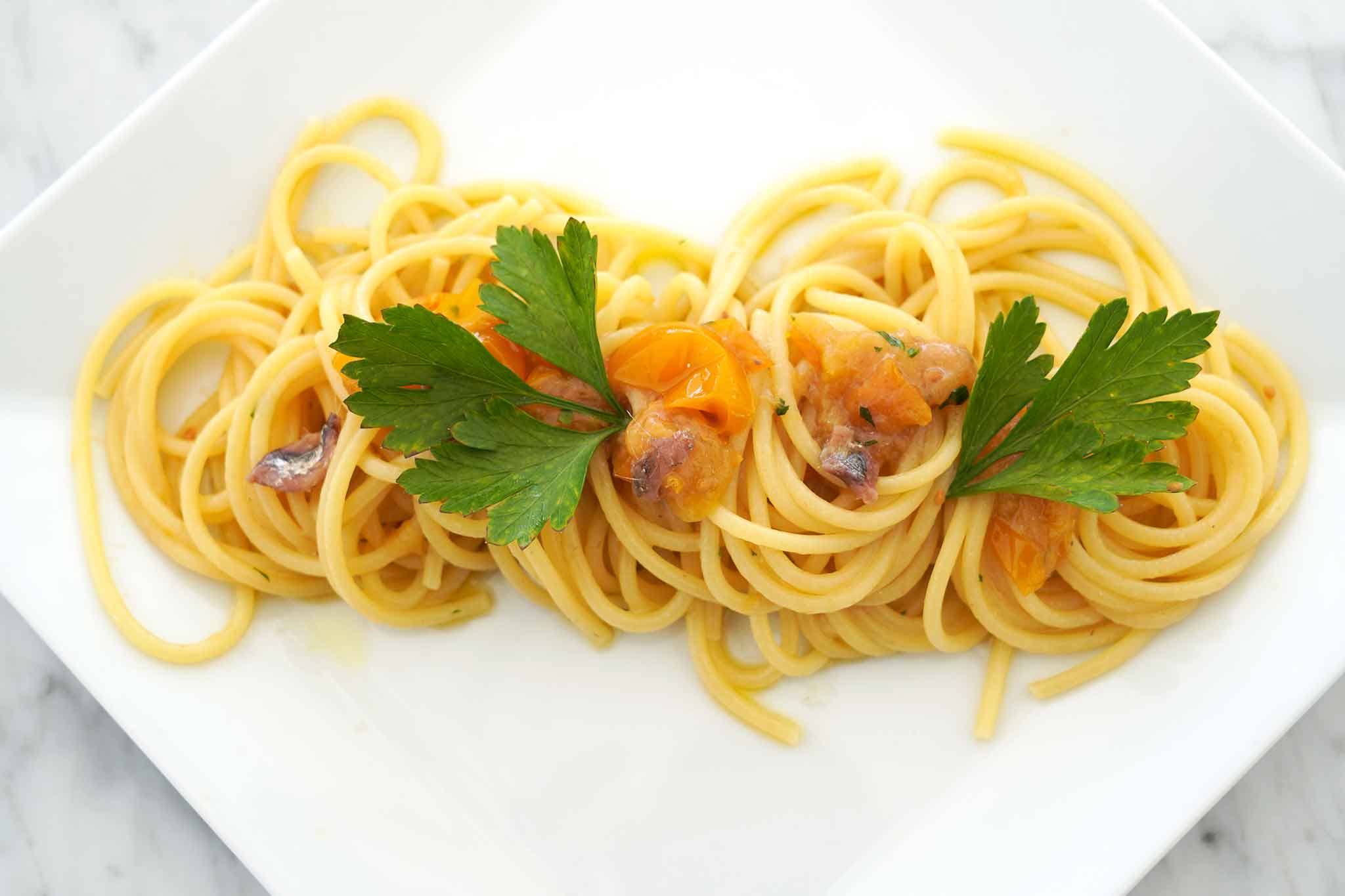 Spaghetti con pomodorini freschi, la ricetta con le alici di menaica