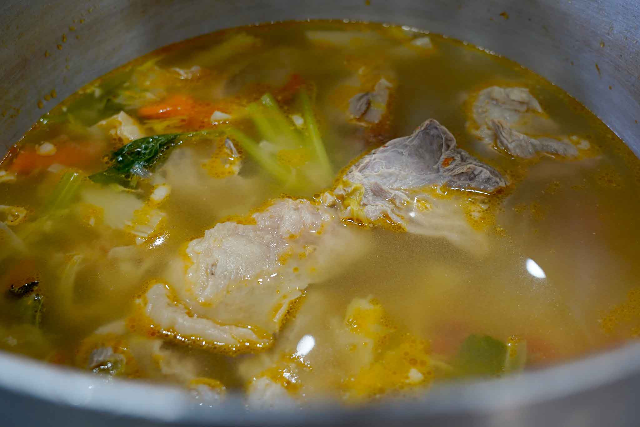 In una pentola capiente versate l’acqua fredda, la carne tagliata a pezzi, le ossa e tutte le verdure mondate e tagliate in maniera grossolana.