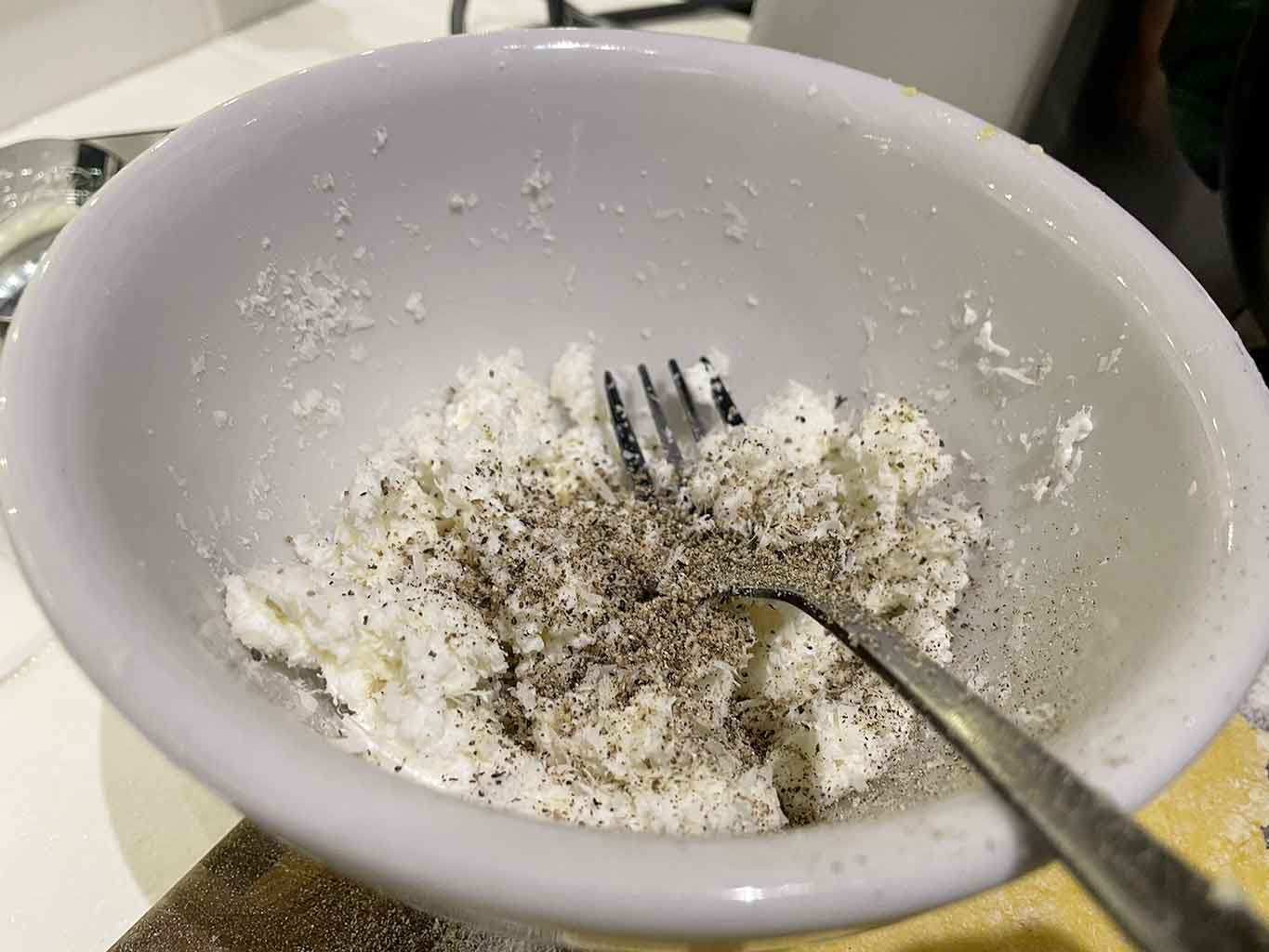 Nell’attesa preparo il ripieno della pasta fresca con i carciofi. Grattugio il pecorino fresco in una ciotola. Aggiungo la ricotta, il pepe, la noce moscata e amalgamo il tutto. Ripongo in frigorifero.