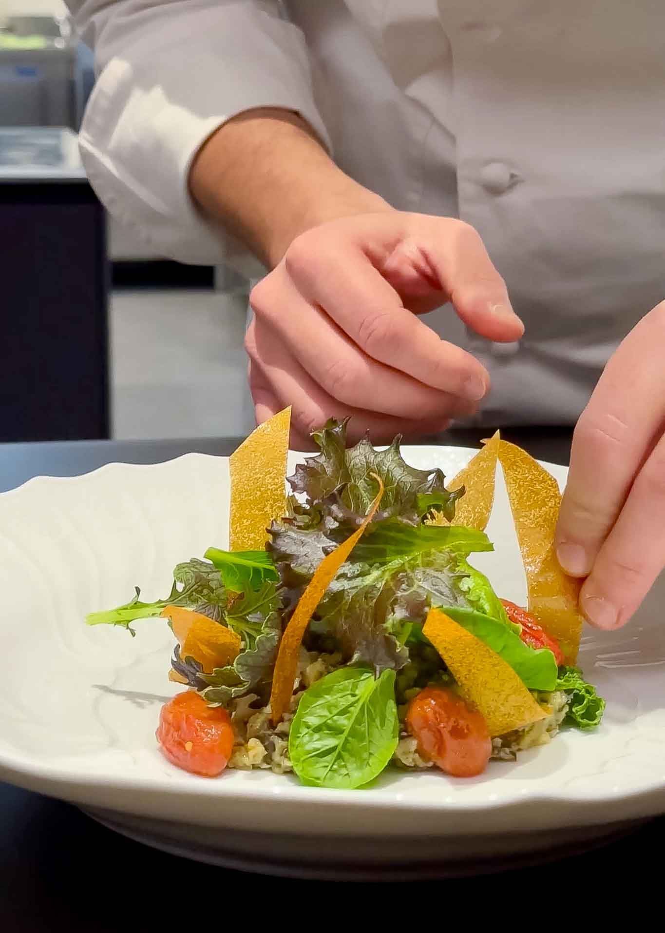 Aggiungere i pomodori confit e le chips di patate.
